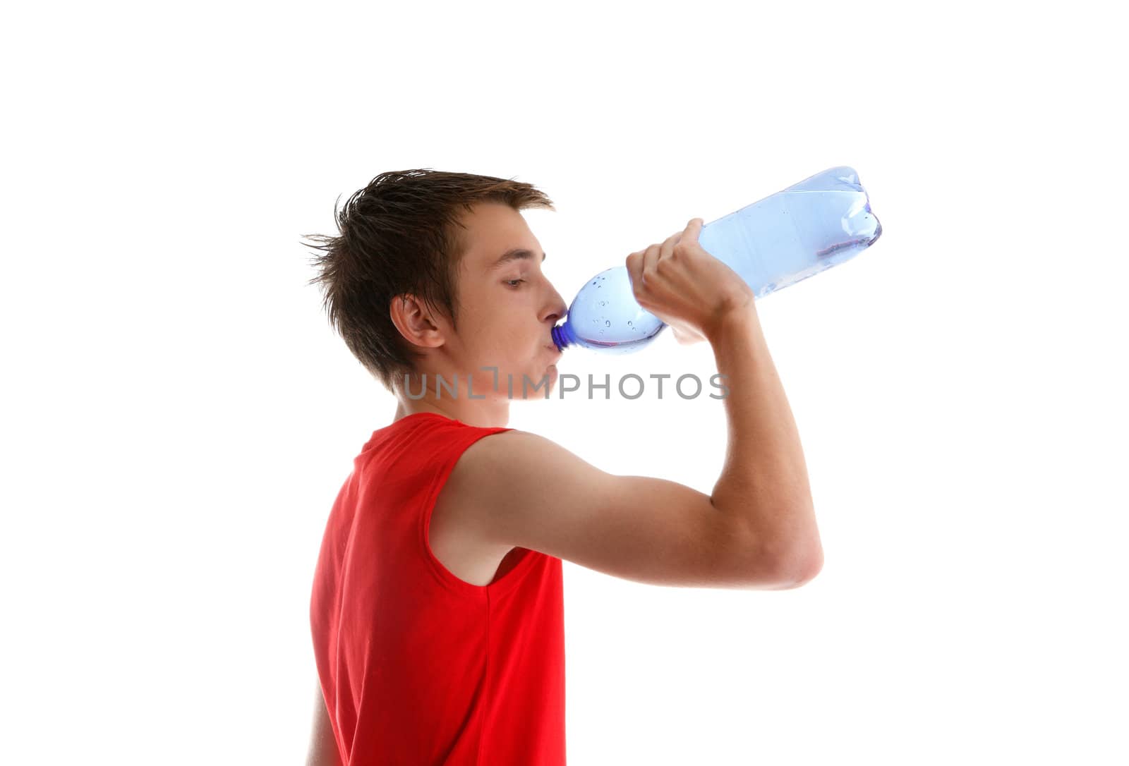 An active young boy teenager drinking bottled water after sport or exercise.  White background.