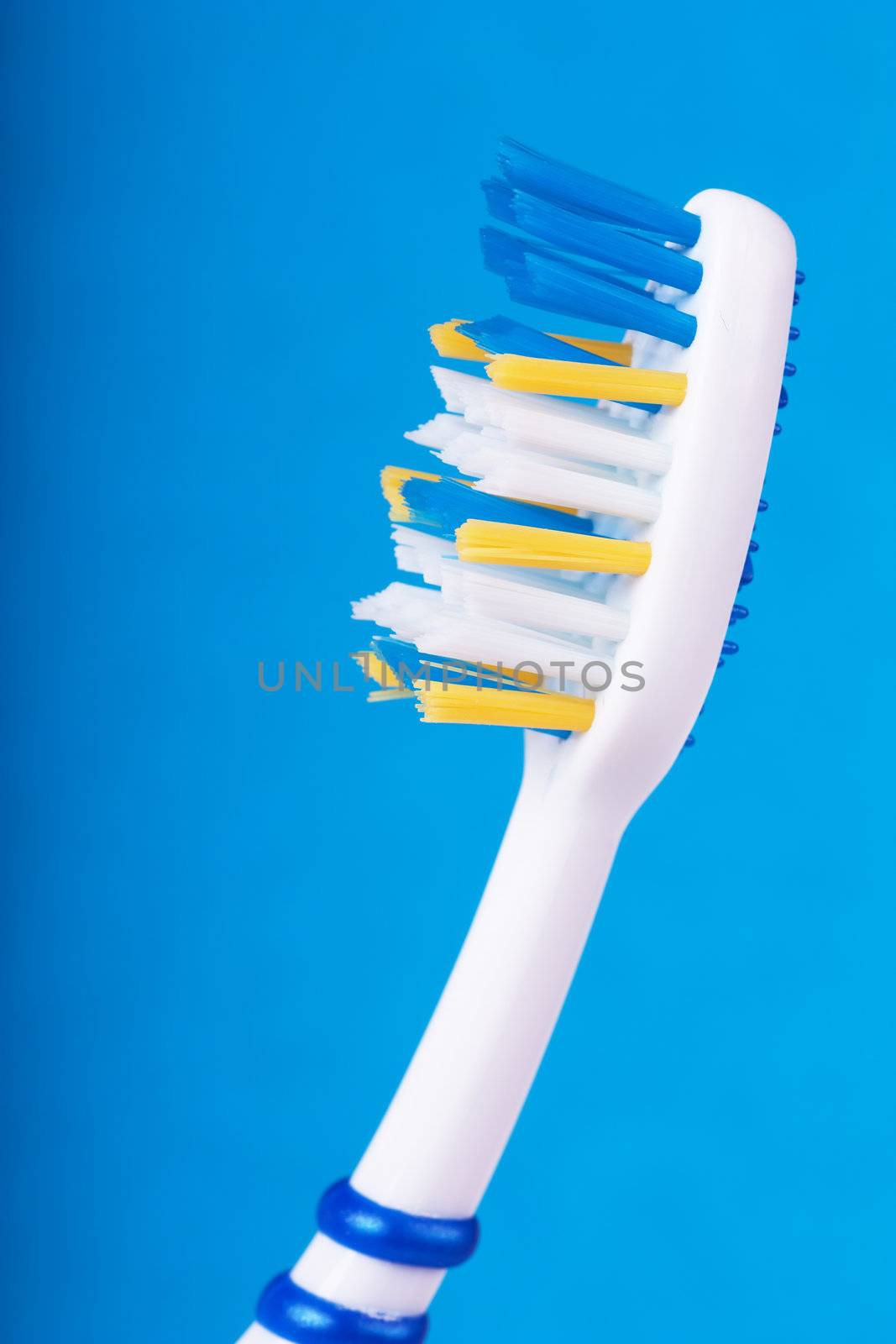 Closeup of toothbrush over blue background