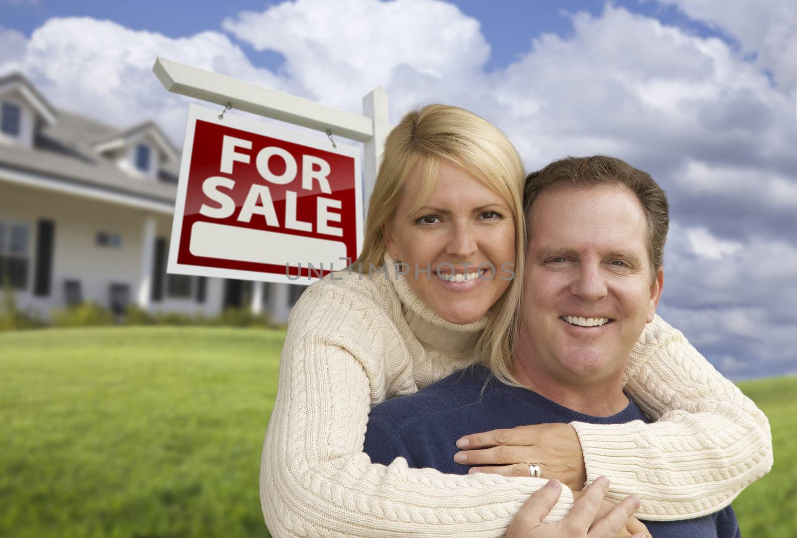 Happy Couple Hugging in Front of Real Estate Sign and House by Feverpitched