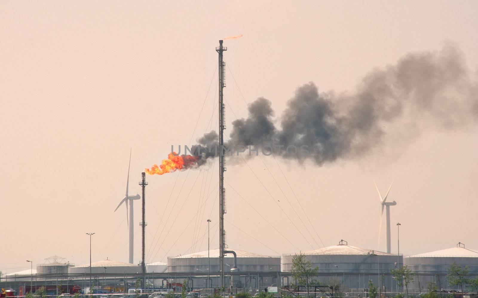 Flare from an oil refinery stack and silo's in Rotterdam Europoort
