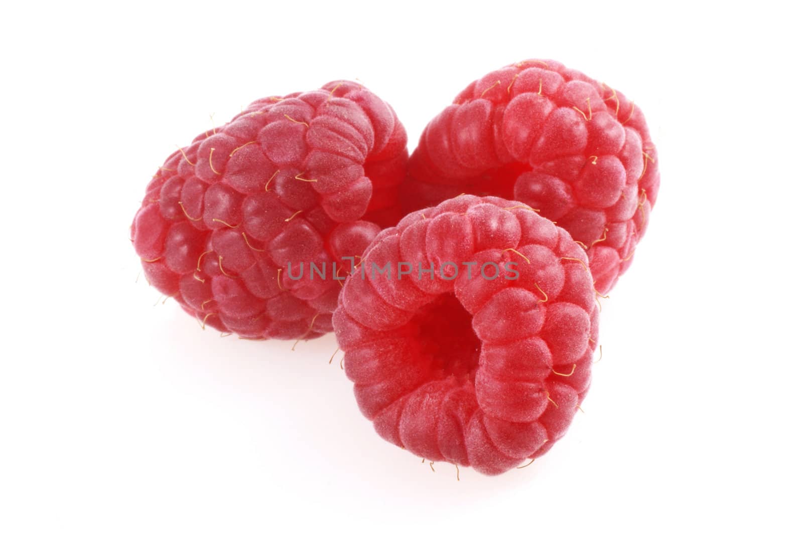 Three raspberries on a white background.