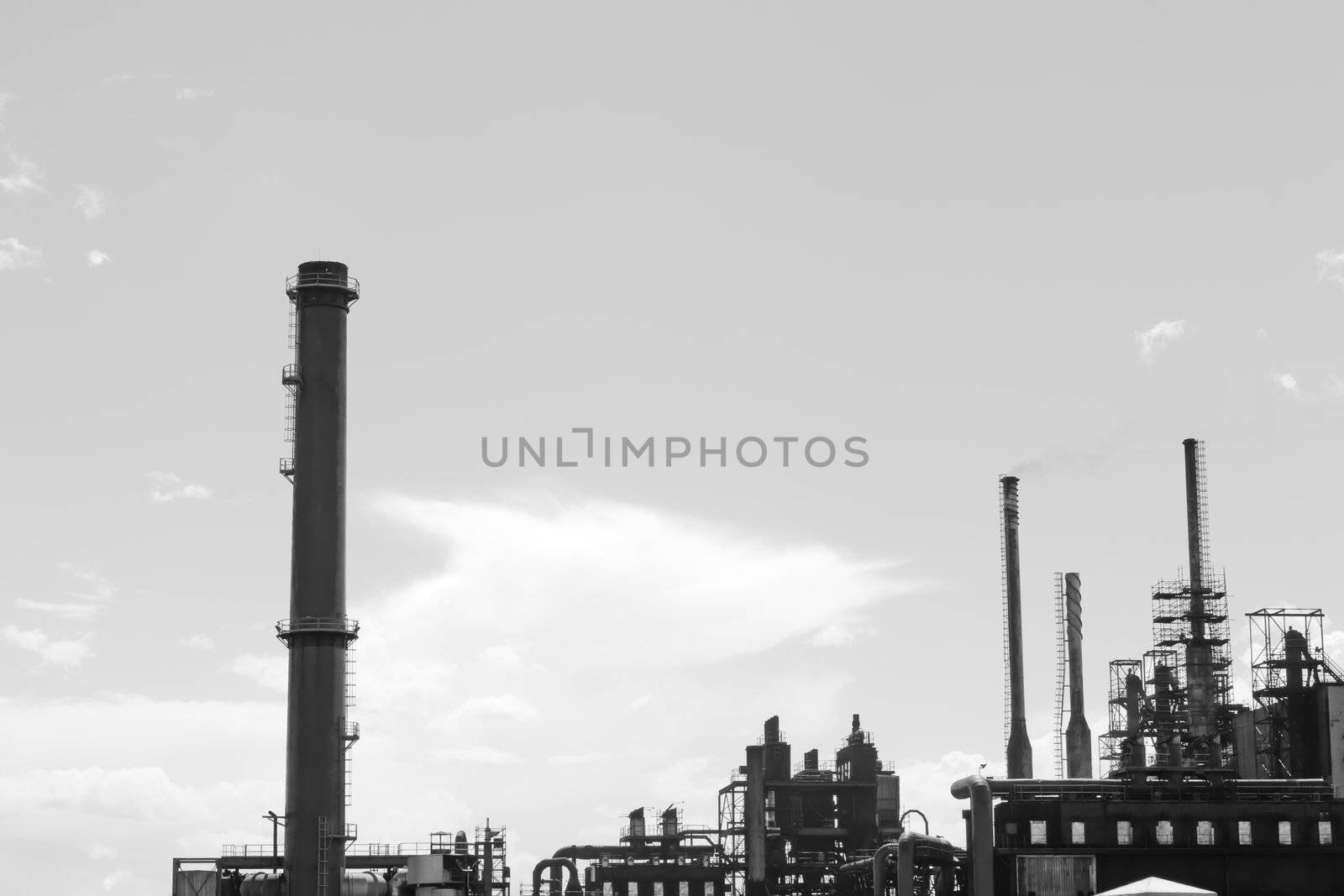 Factory with smoke stacks against blue sky