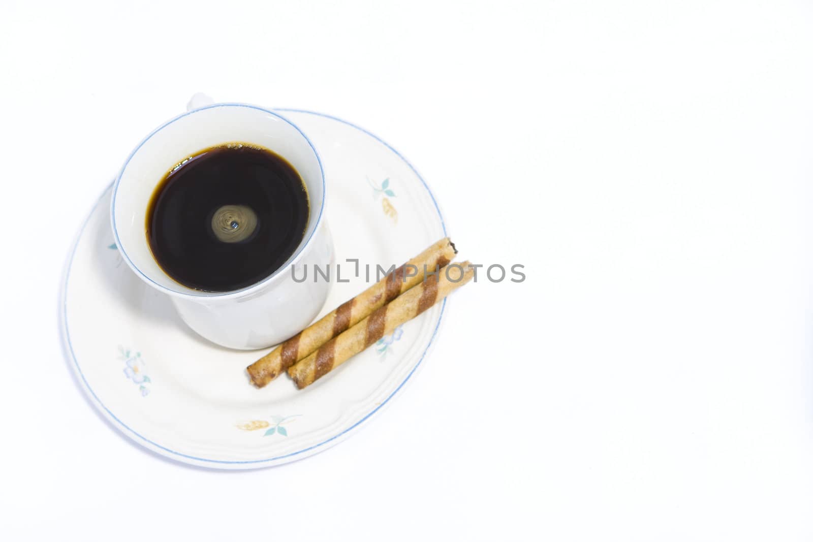 Cup of black coffee and wafer biscuit on white background