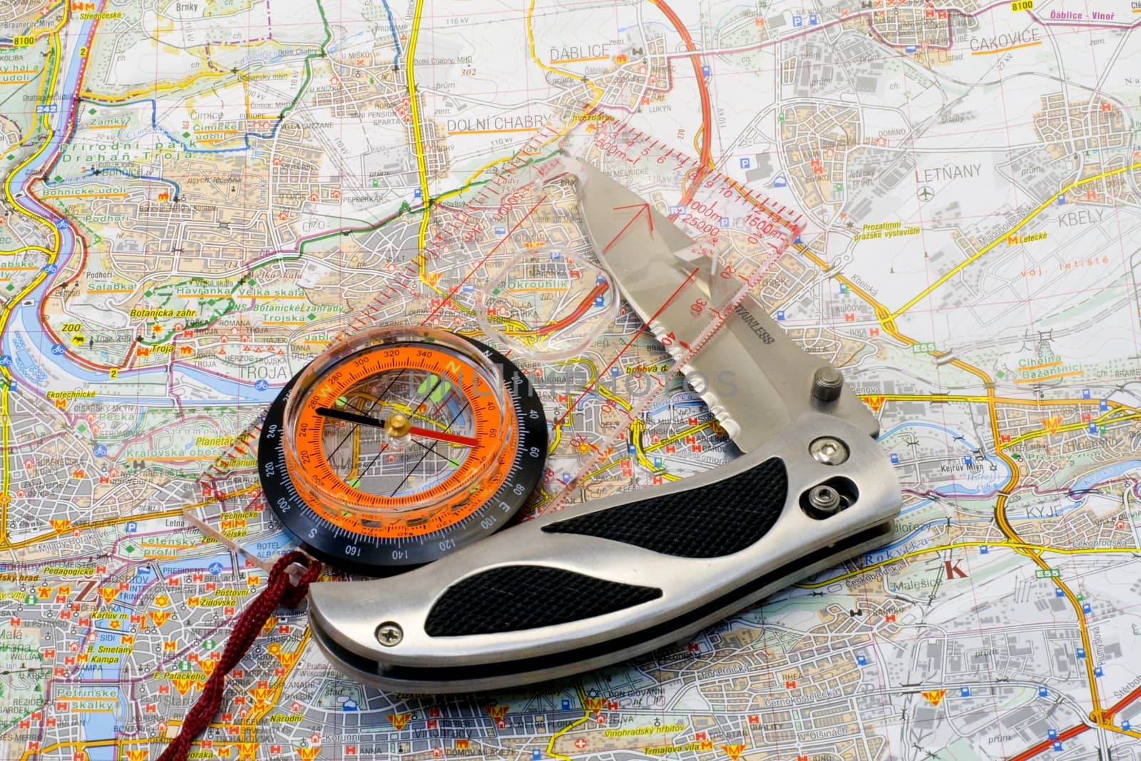 a compass and a knife lying on a map - close up