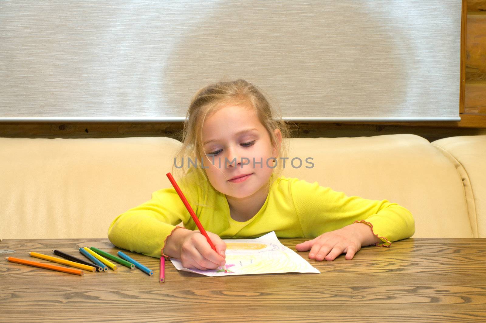 Portrait of the smiling lovely girl drawing color pencils.