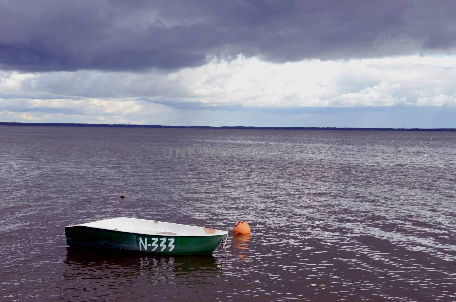 Plastic boat with number stand alone near orange buoy.