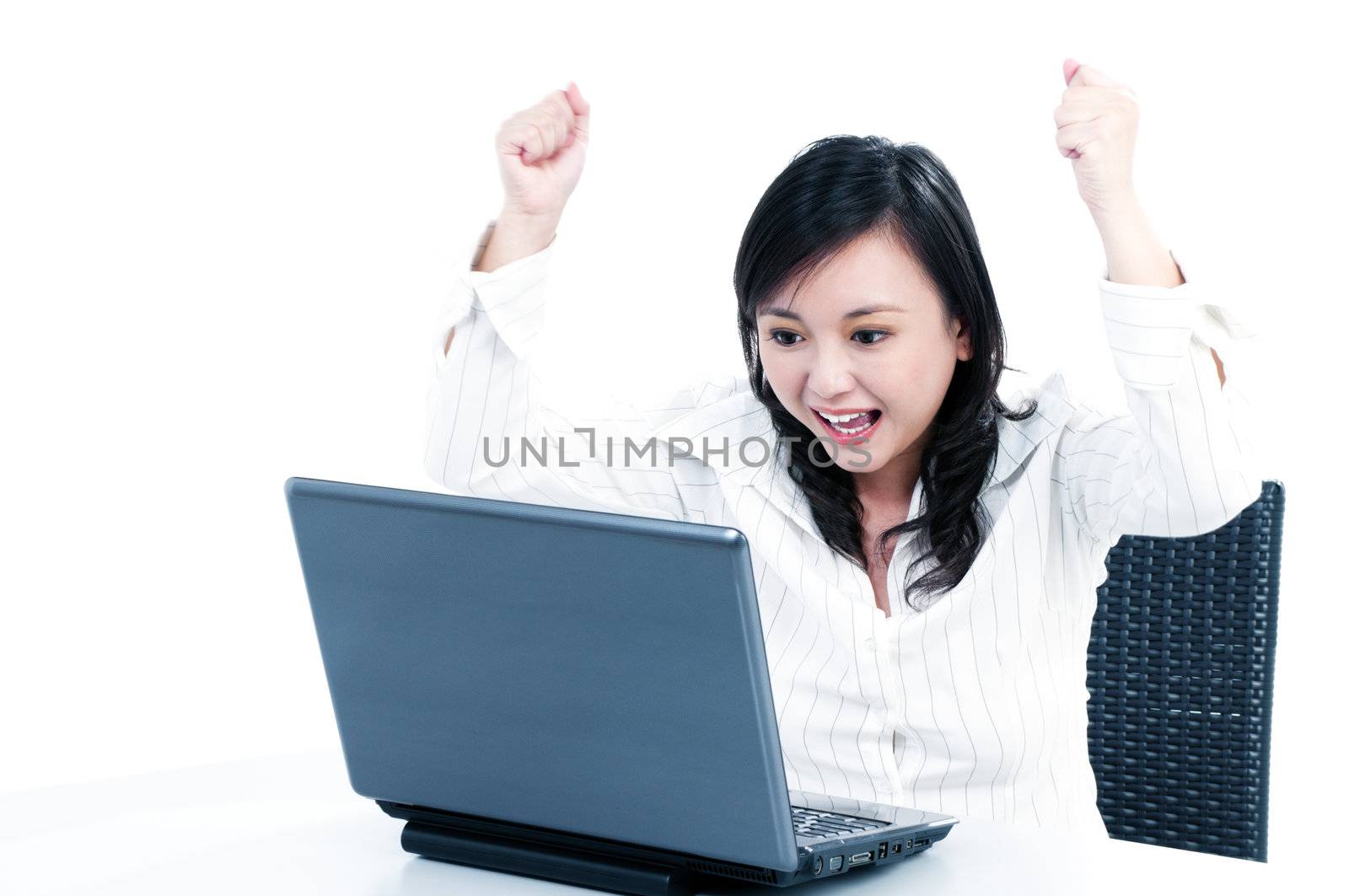 Portrait of a happy young businesswoman cheering in front of laptop, over white background.