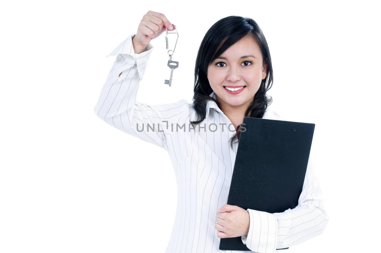 Portrait of an attractive businesswoman holding clipboard and key, over white background.