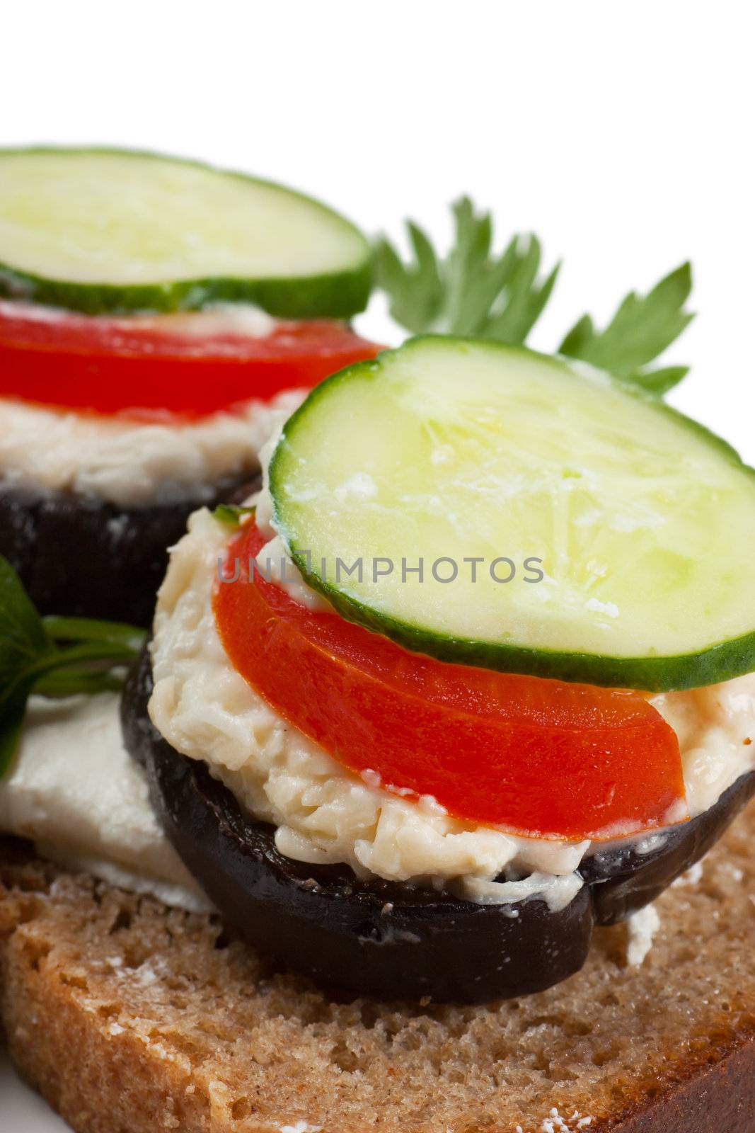 Open sandwich with aubergine and cucumbers over white background