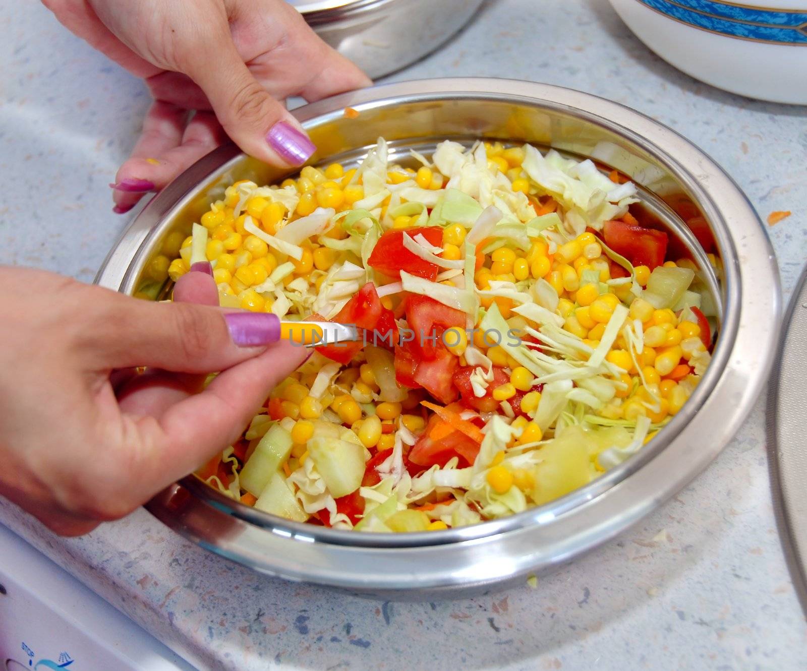 hands preparing appetizing corn salad with vegetables