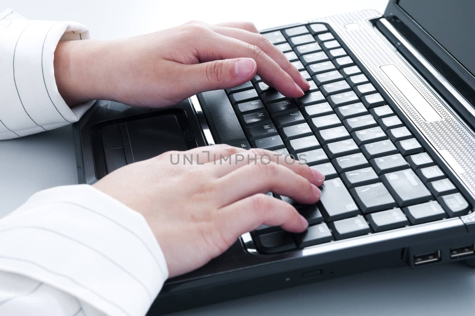 Closeup of hands typing on keyboard.