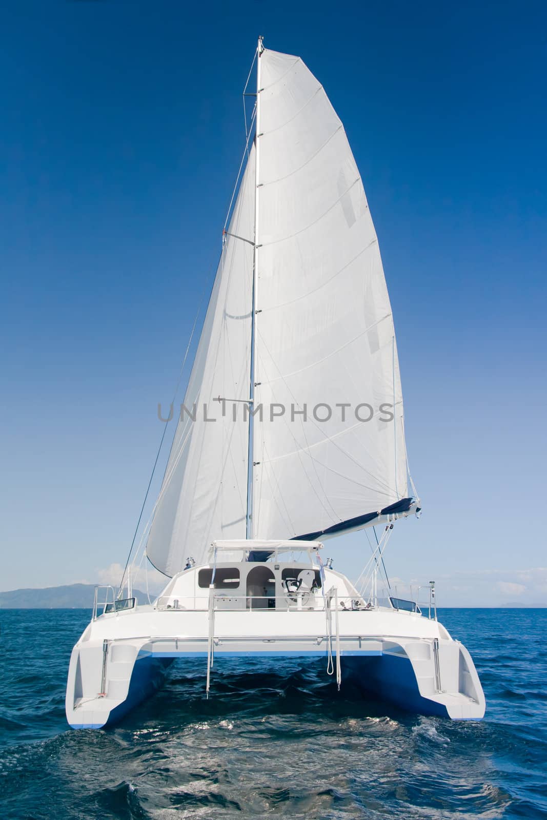 Luxury white catamaran boat in the ocean with blue sky