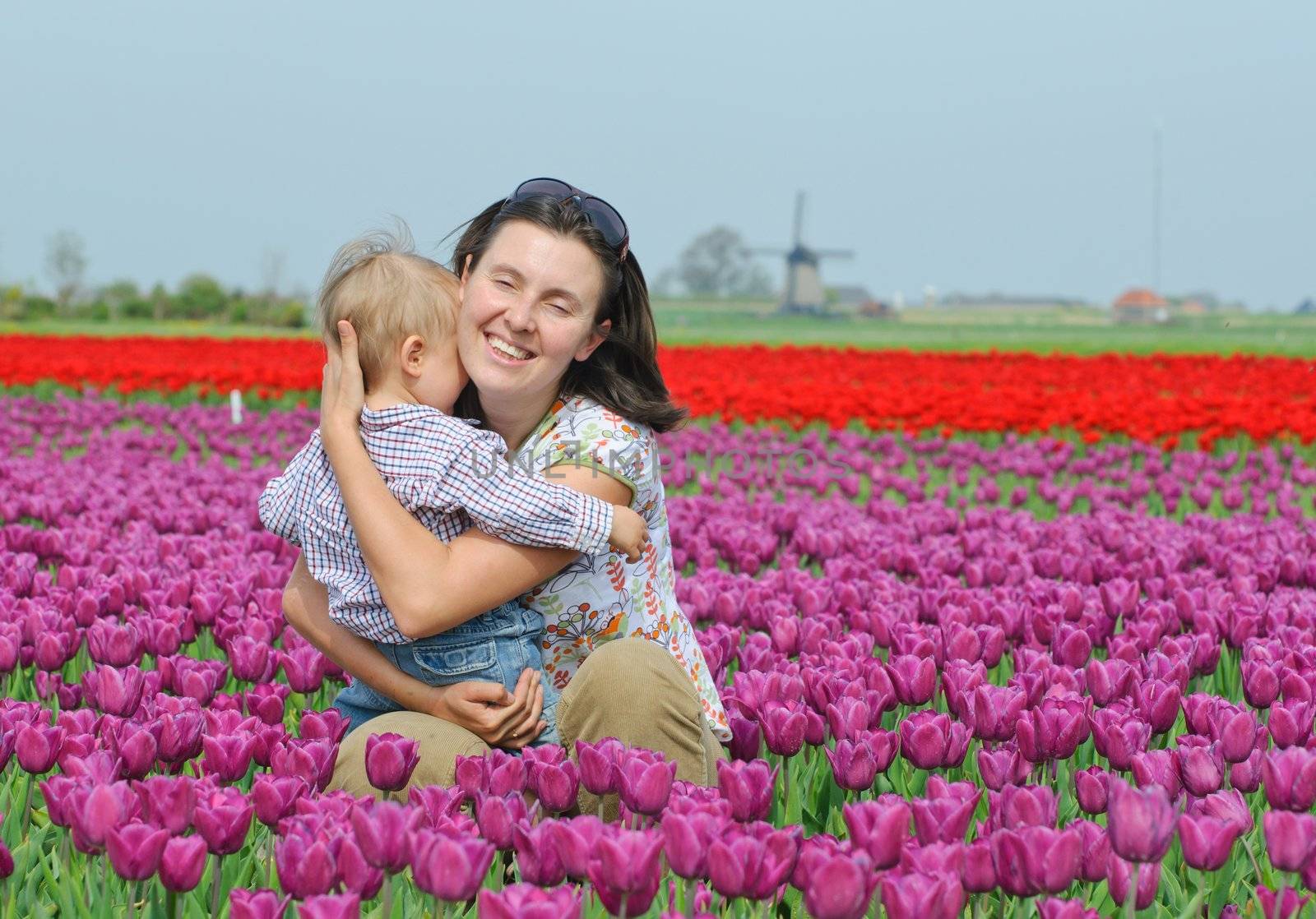 Mother with son in the purple tulips field