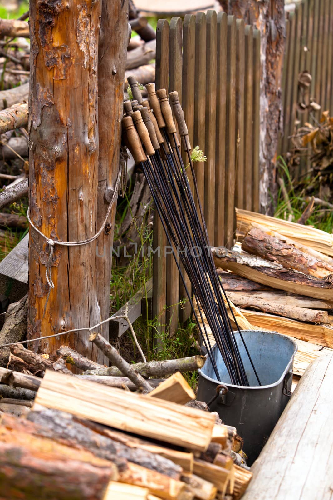 Wooden fence and steel sticks for barbecue
