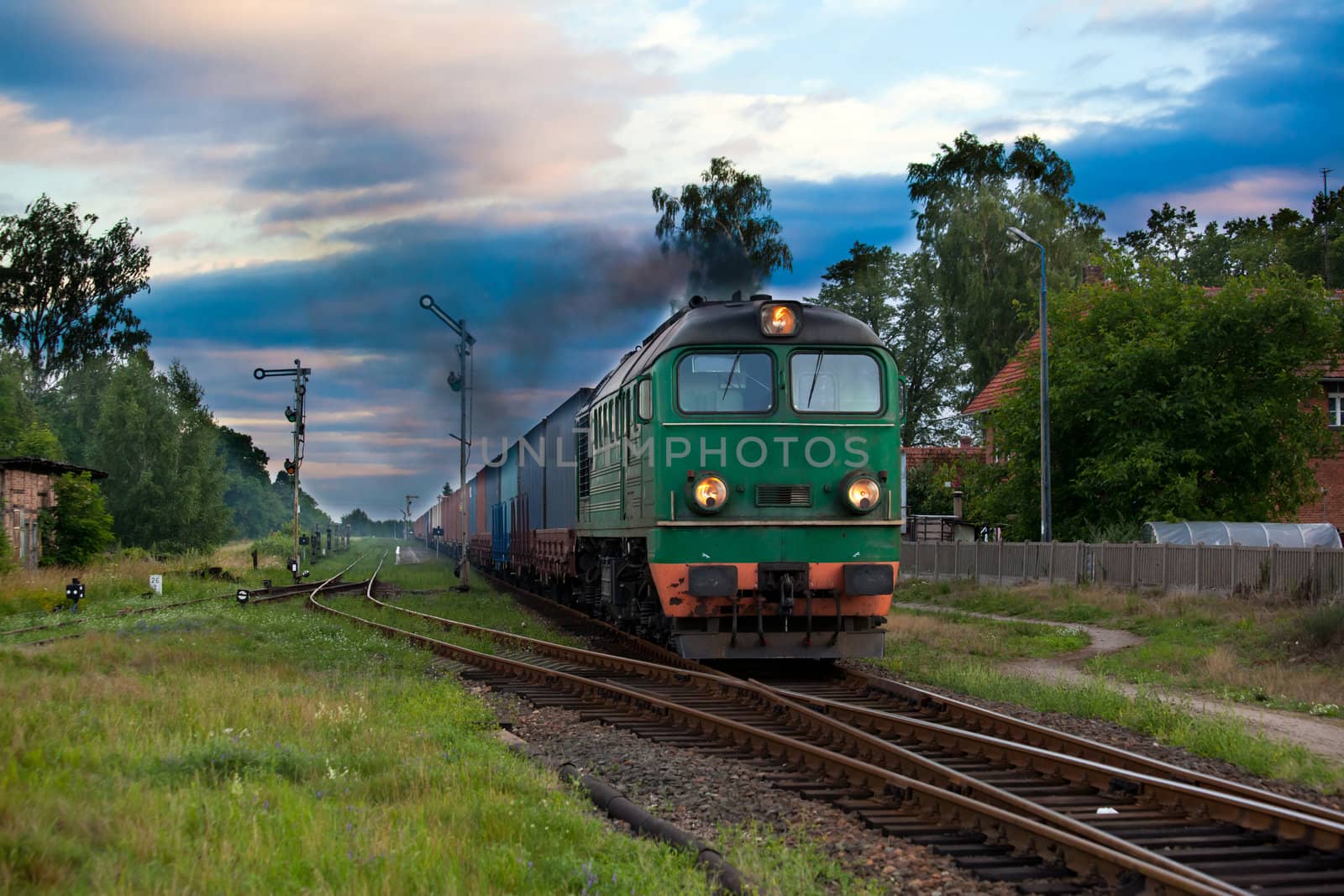Freight train hauled by the diesel locomotive passing the station
