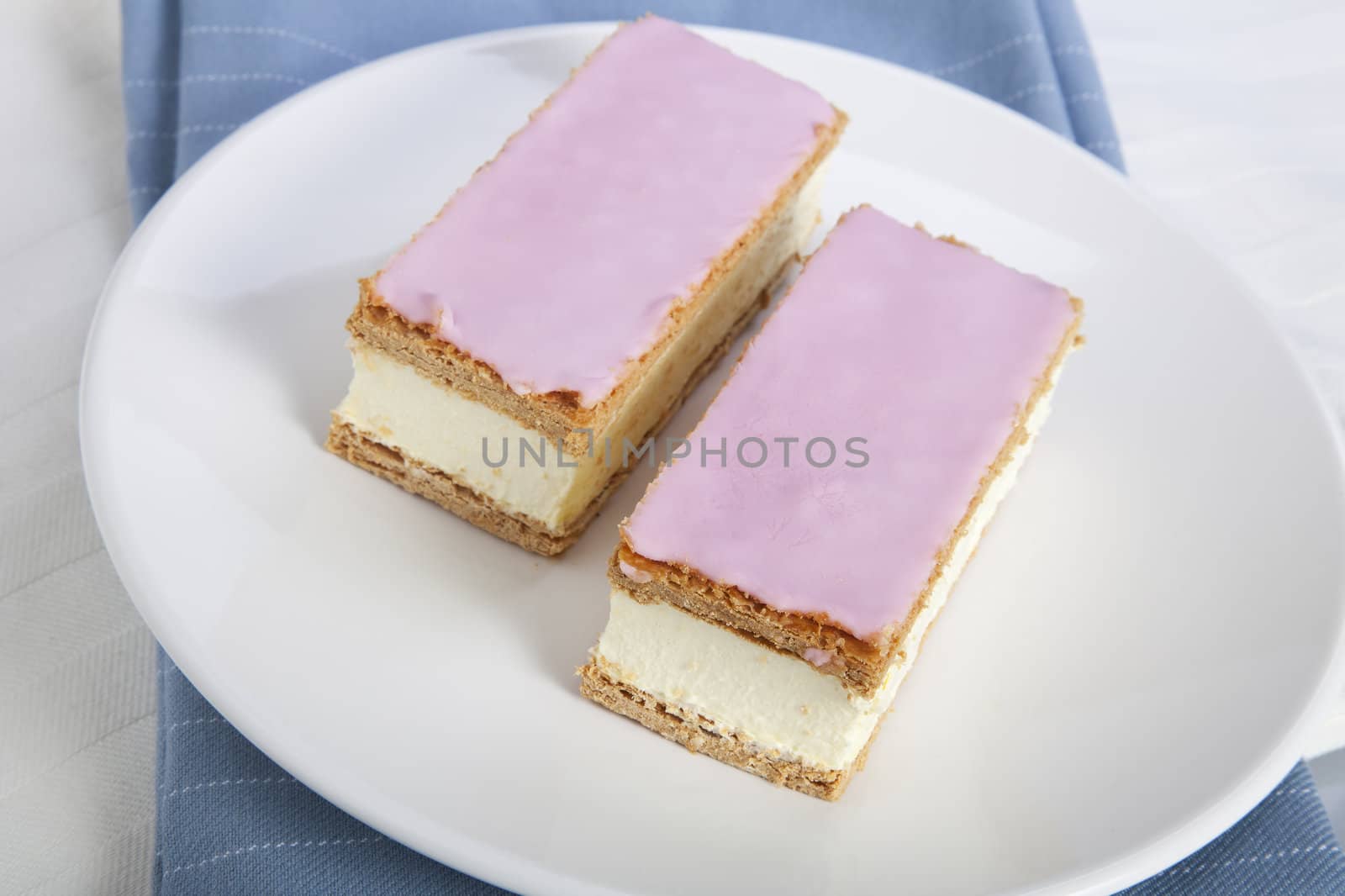 Tompouce, a common pastry  in the Netherlands and Belgium made  with puff pastry , filled with sweet yellow pastry cream and topped with pink icing.