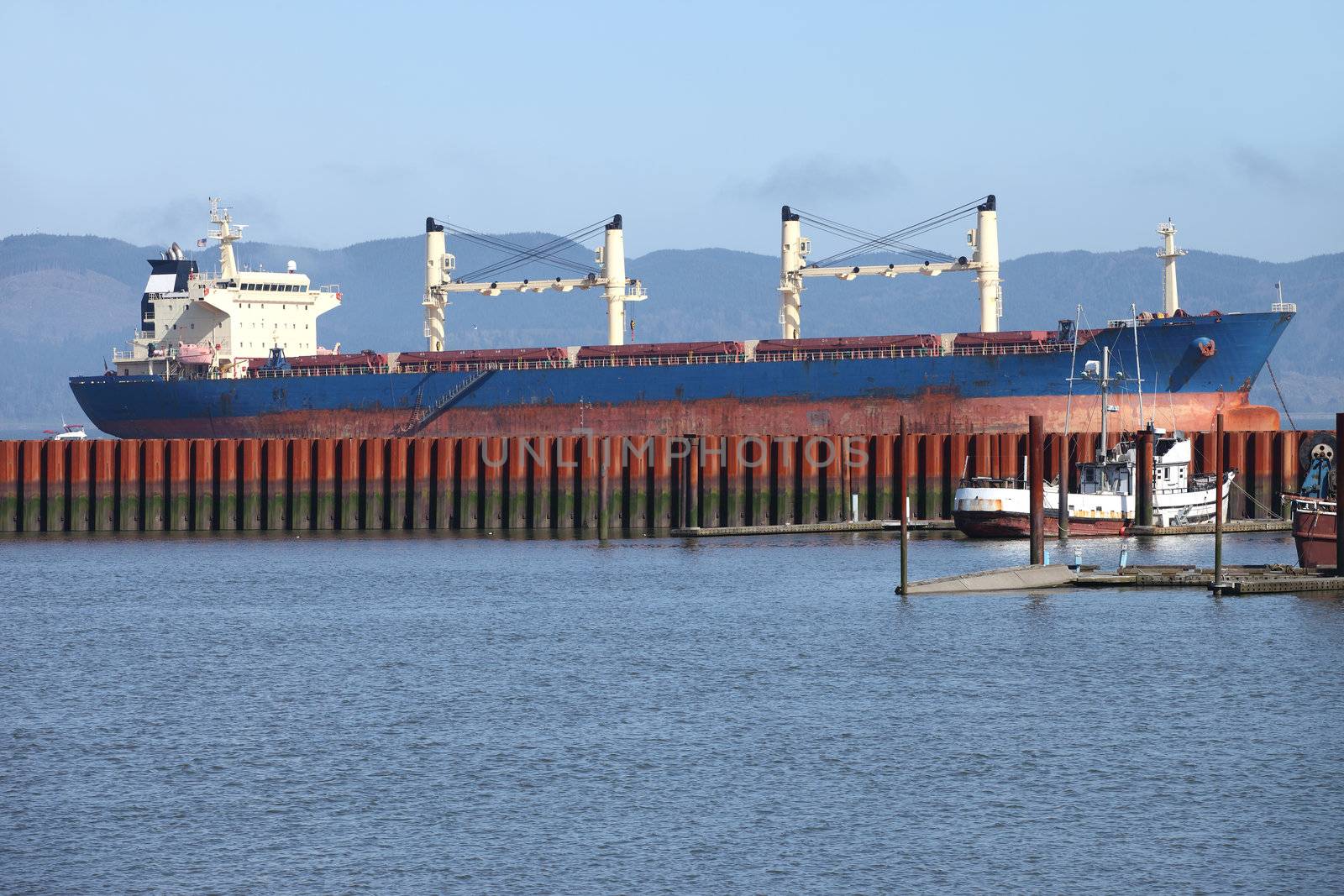 A large cargo ship anchored in the Astoria bay in the early morning.