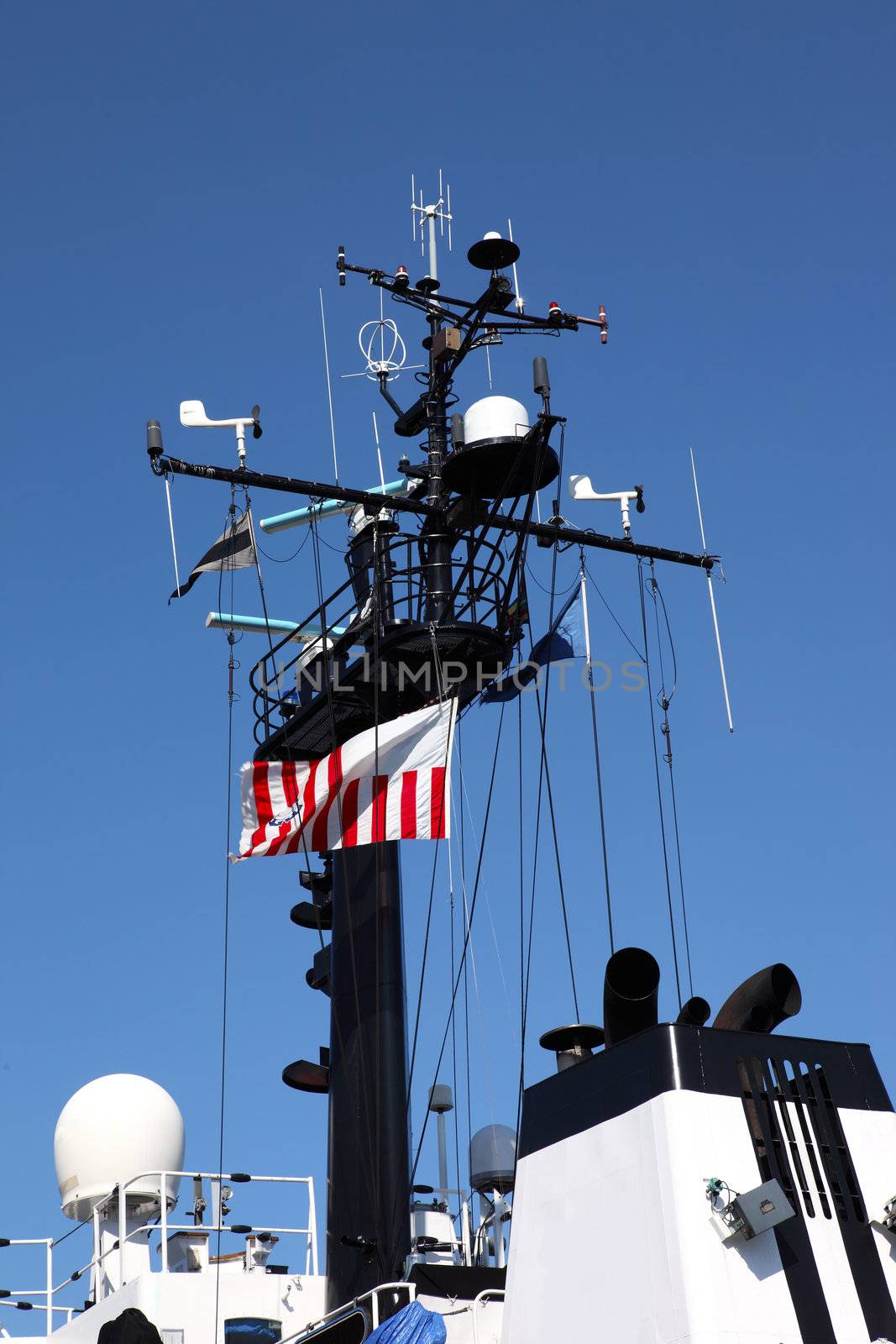A coast guard ship mast decorated with electronics.