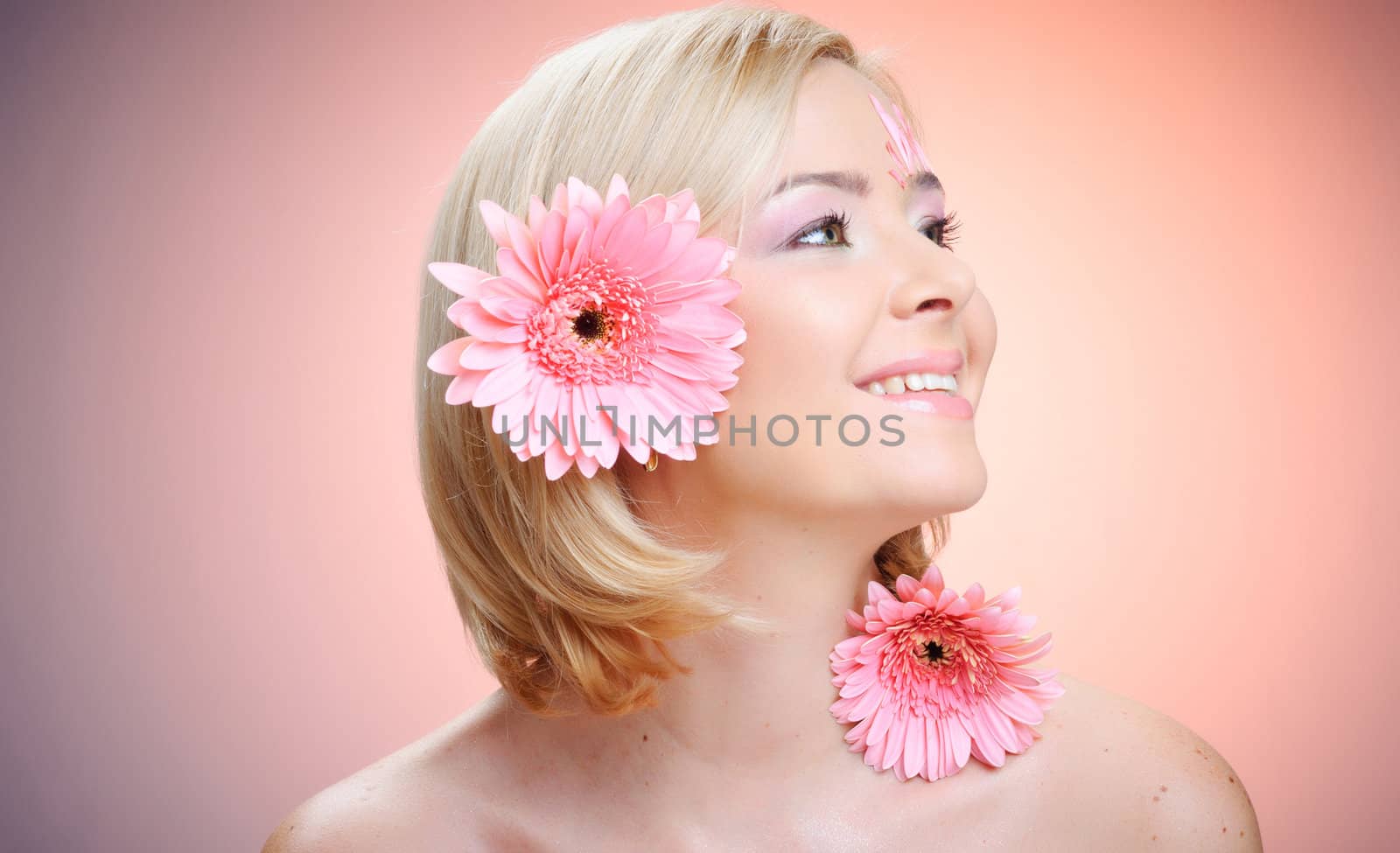 Close-up of woman green eye. Pink flower on background.