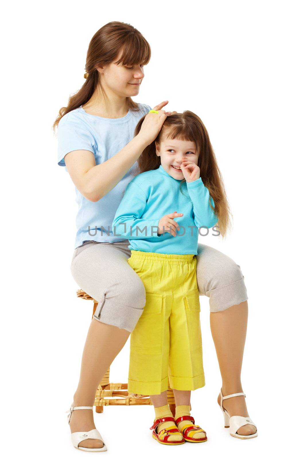 Mom makes daughter hairstyle isolated on white background