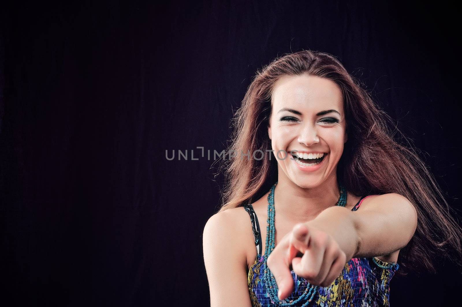 Joyful woman with long brown hairs. Isolated on black