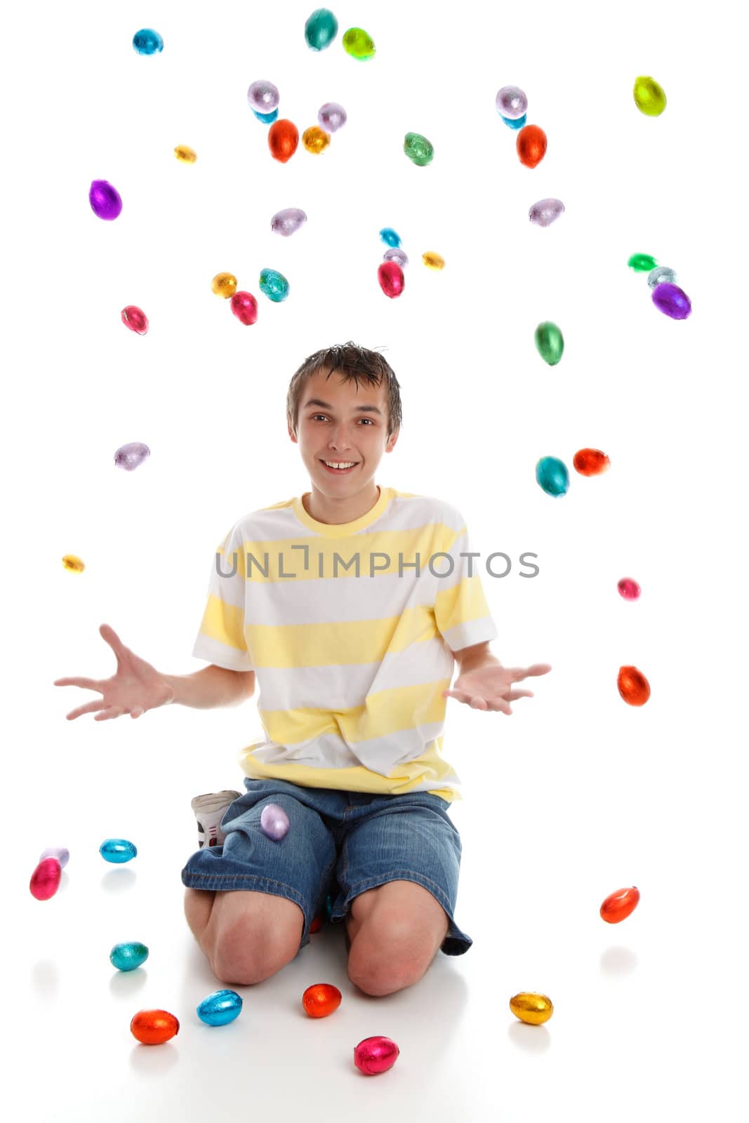 Excited happy boy with many easter eggs all around him.  White background.