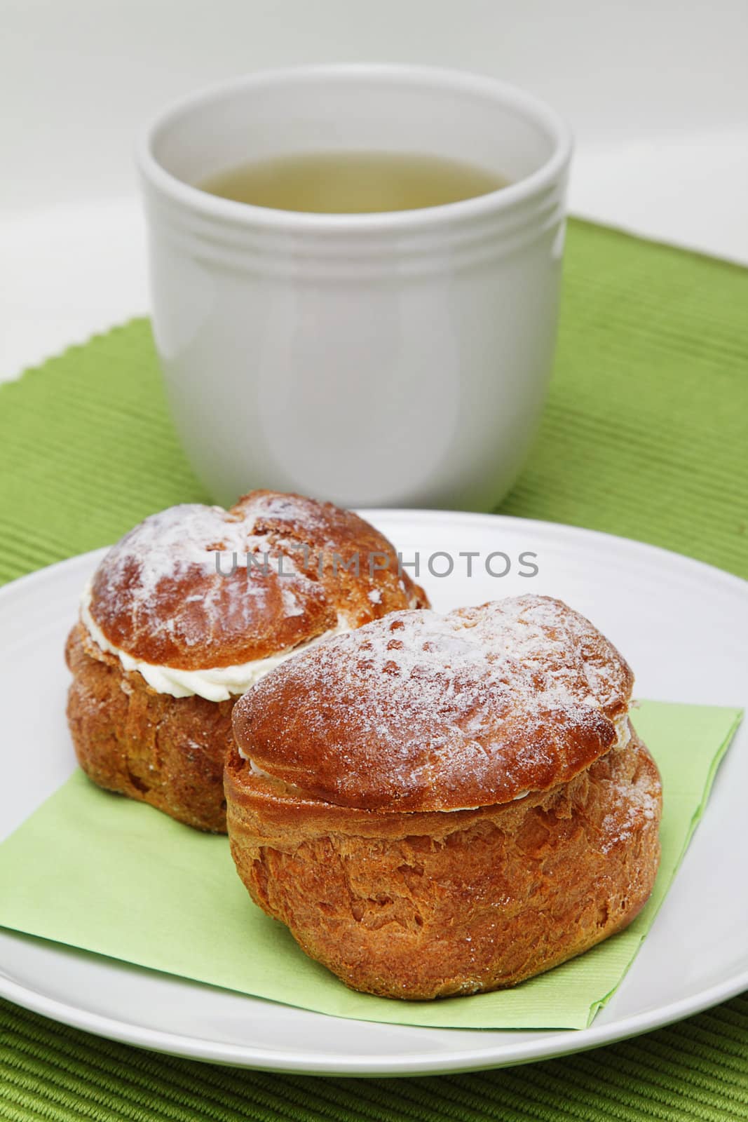 Two profiteroles and a cup of green tea