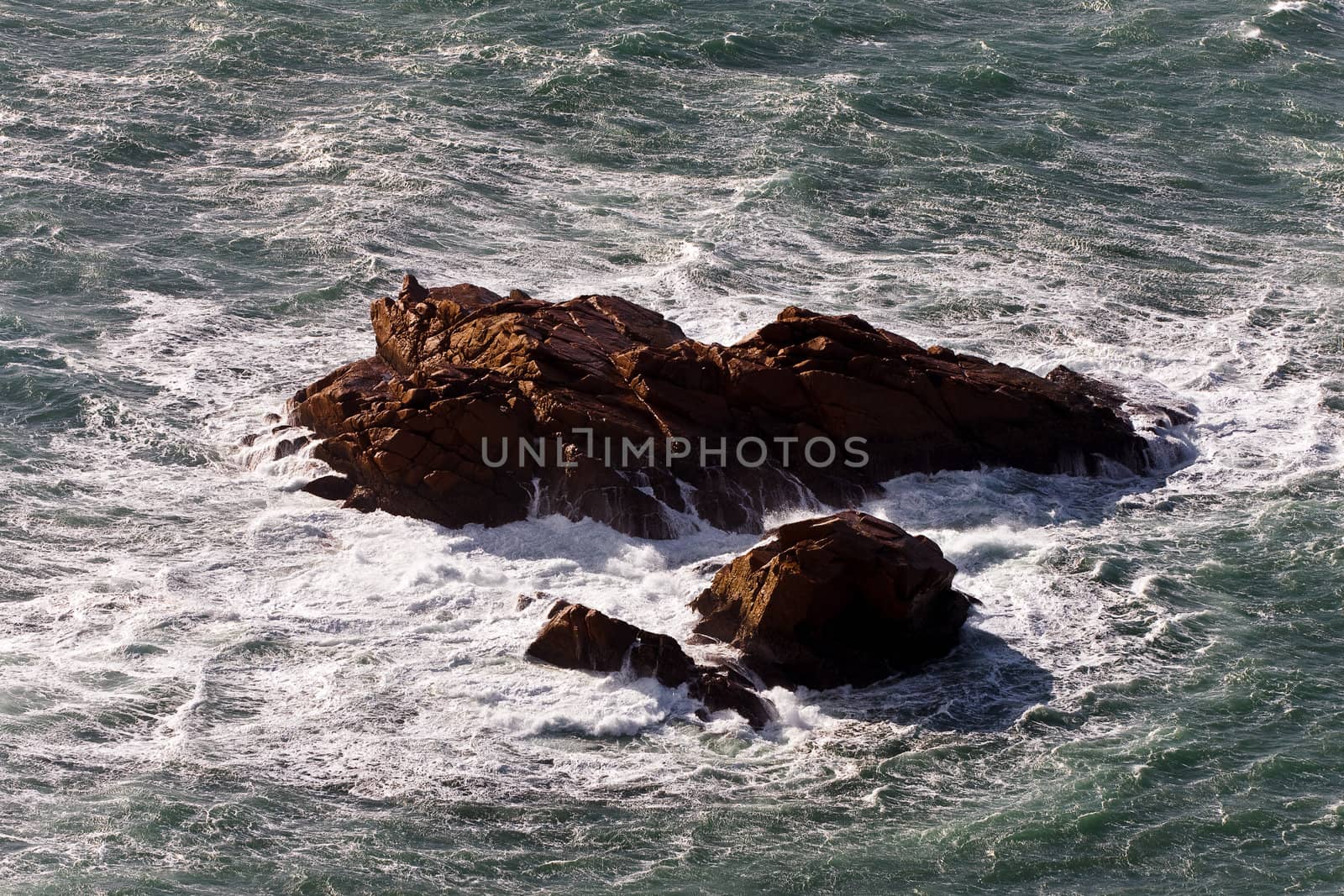 The brown rock in a stormy ocean