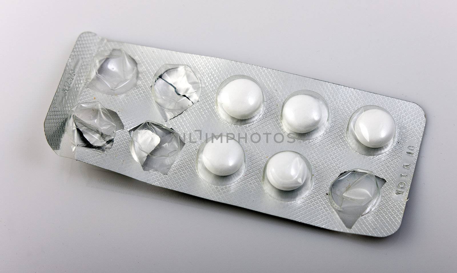 used packaging of pills and reflecting, gray background