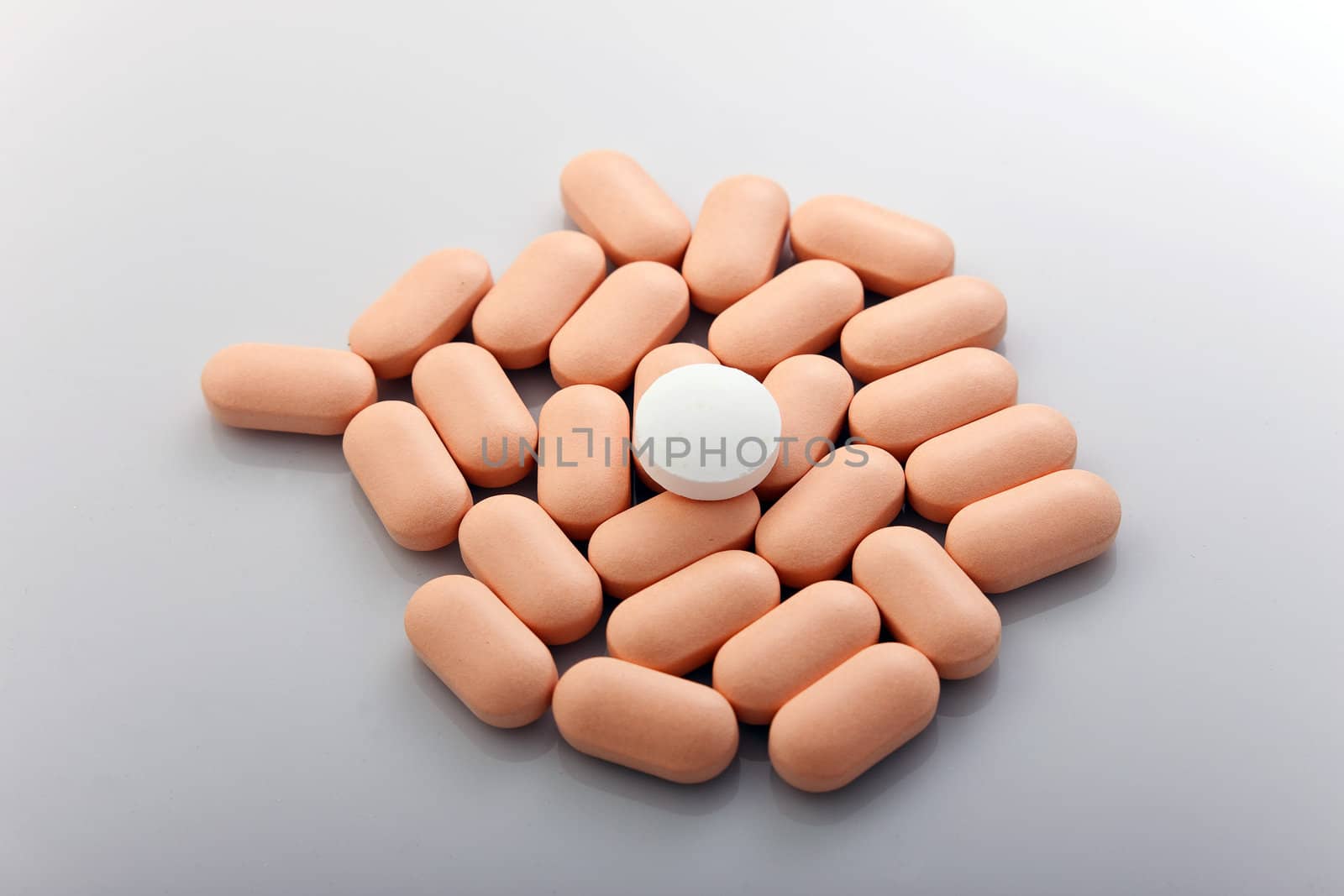 A handful of rose pills on a gray background