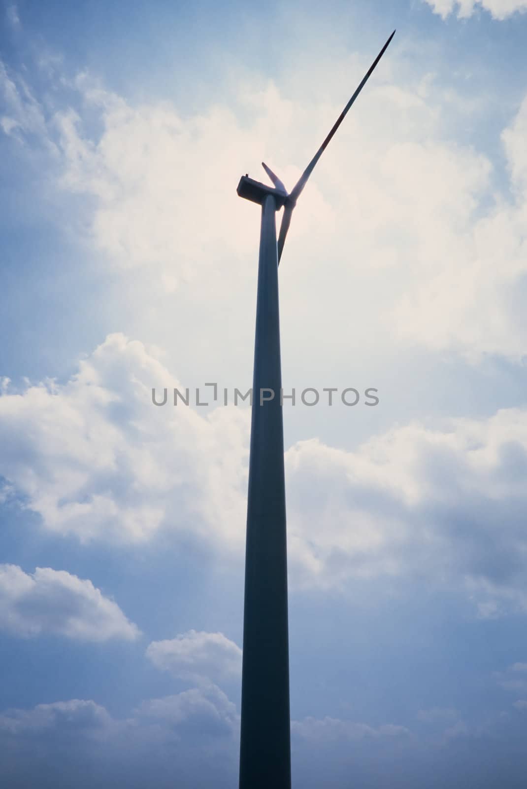 Silhouette of big 1.3MW wind turbine with sun right behind it.