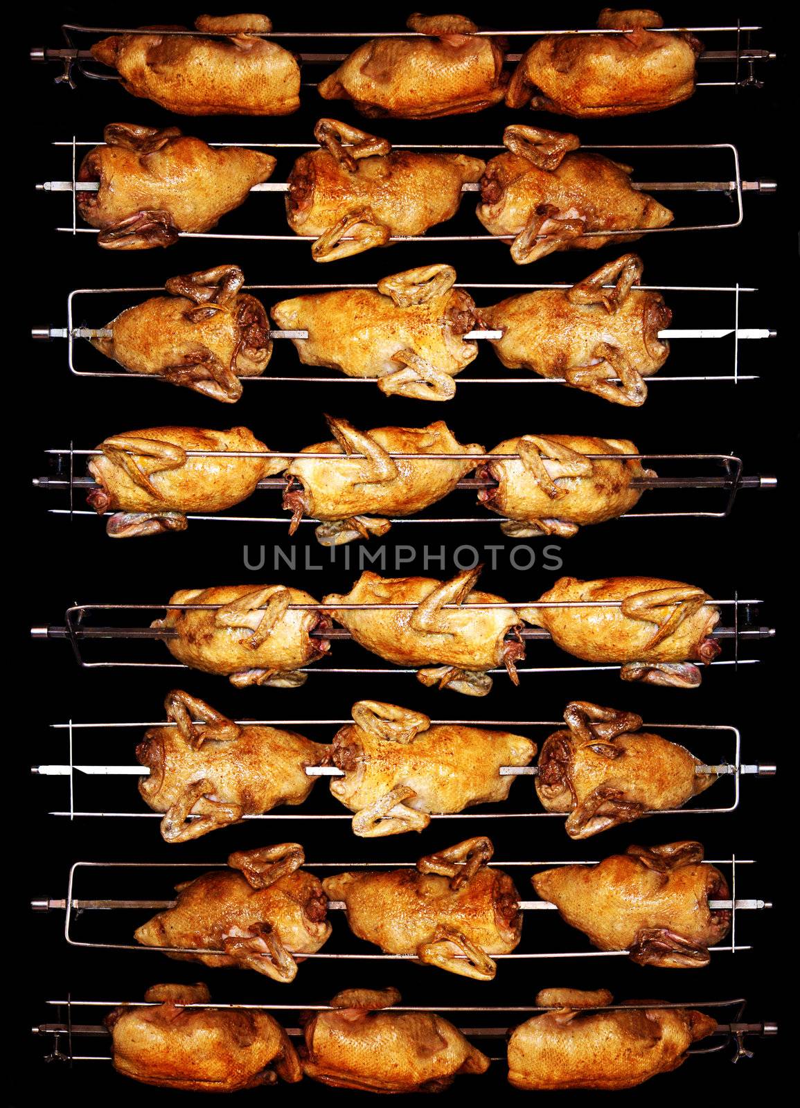 Tasty grilled chicken turn golden brown on the spit