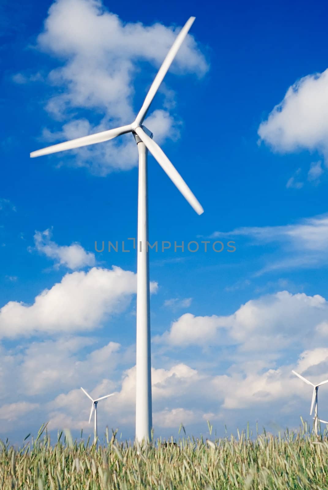 Wind turbines/ windfarm on farmland (slight motion blur on rotors)