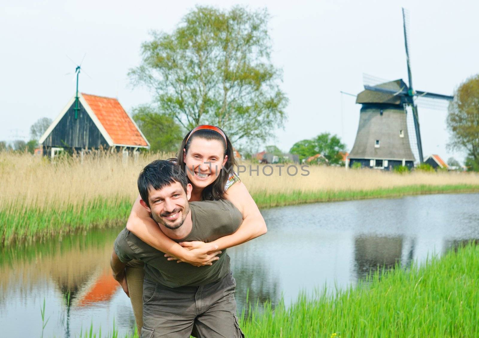 Happy young couple have fun near Duch mills