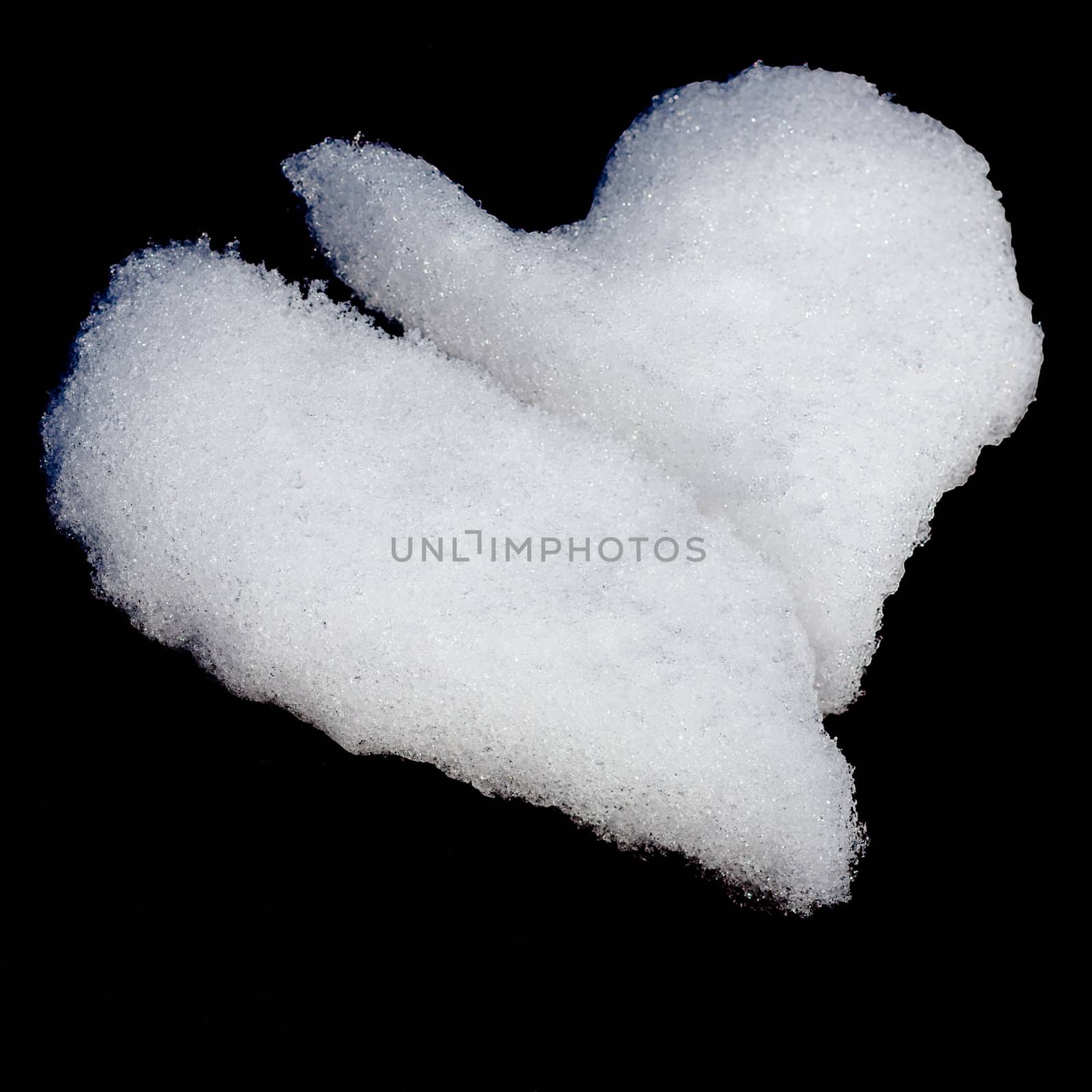 Broken heart formed from snow isolated on black background.