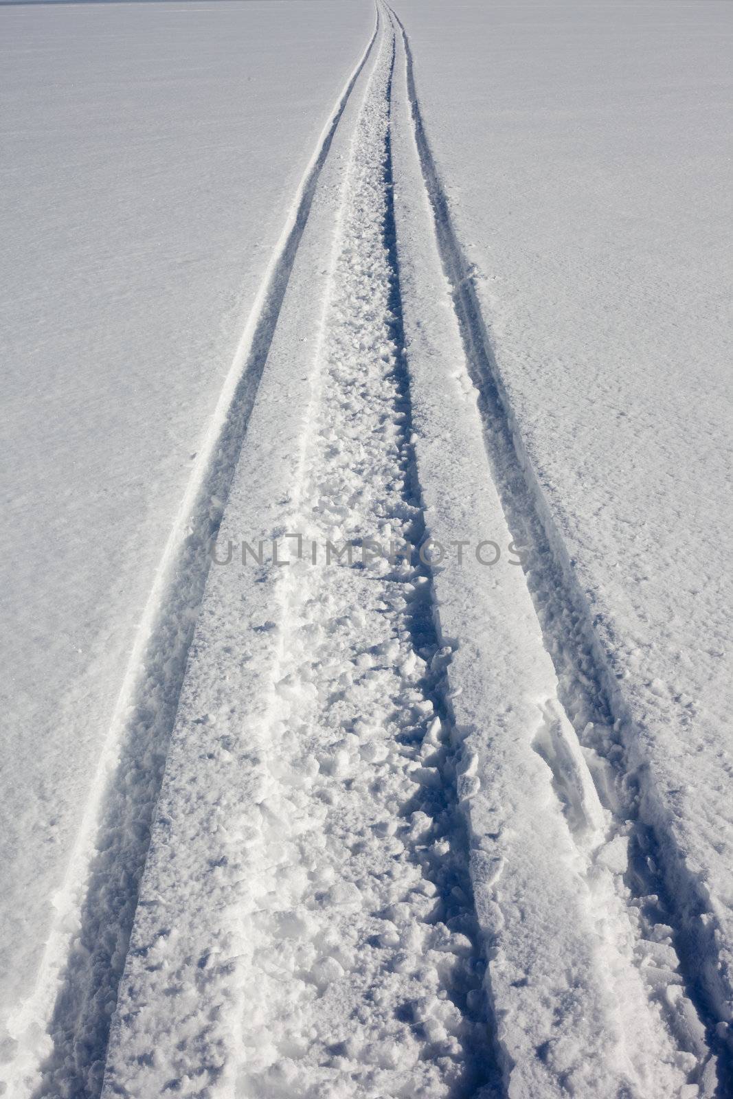 Concept of snowmobile track in clean fresh snow leading nowhere.