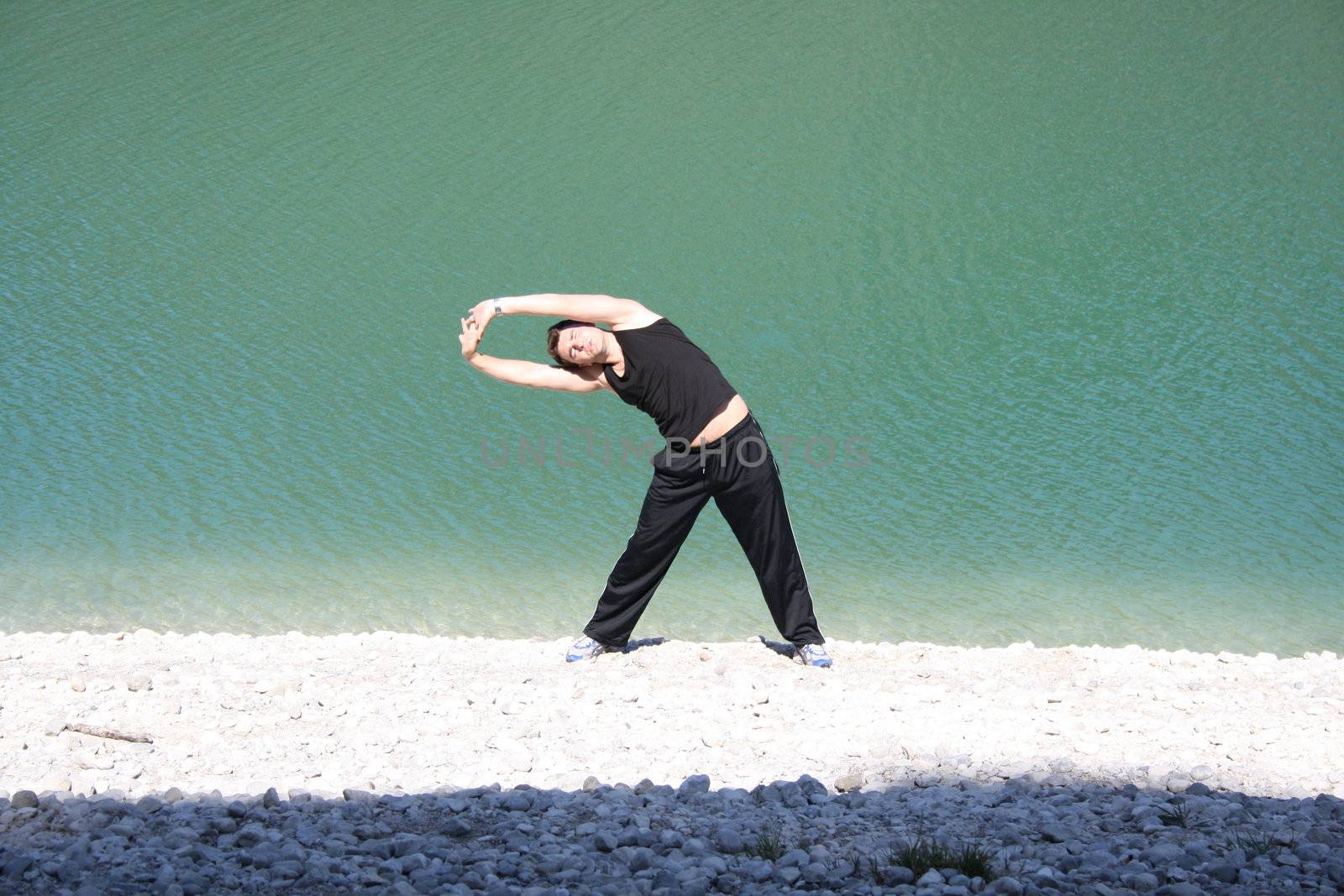 Young man stretching on beach