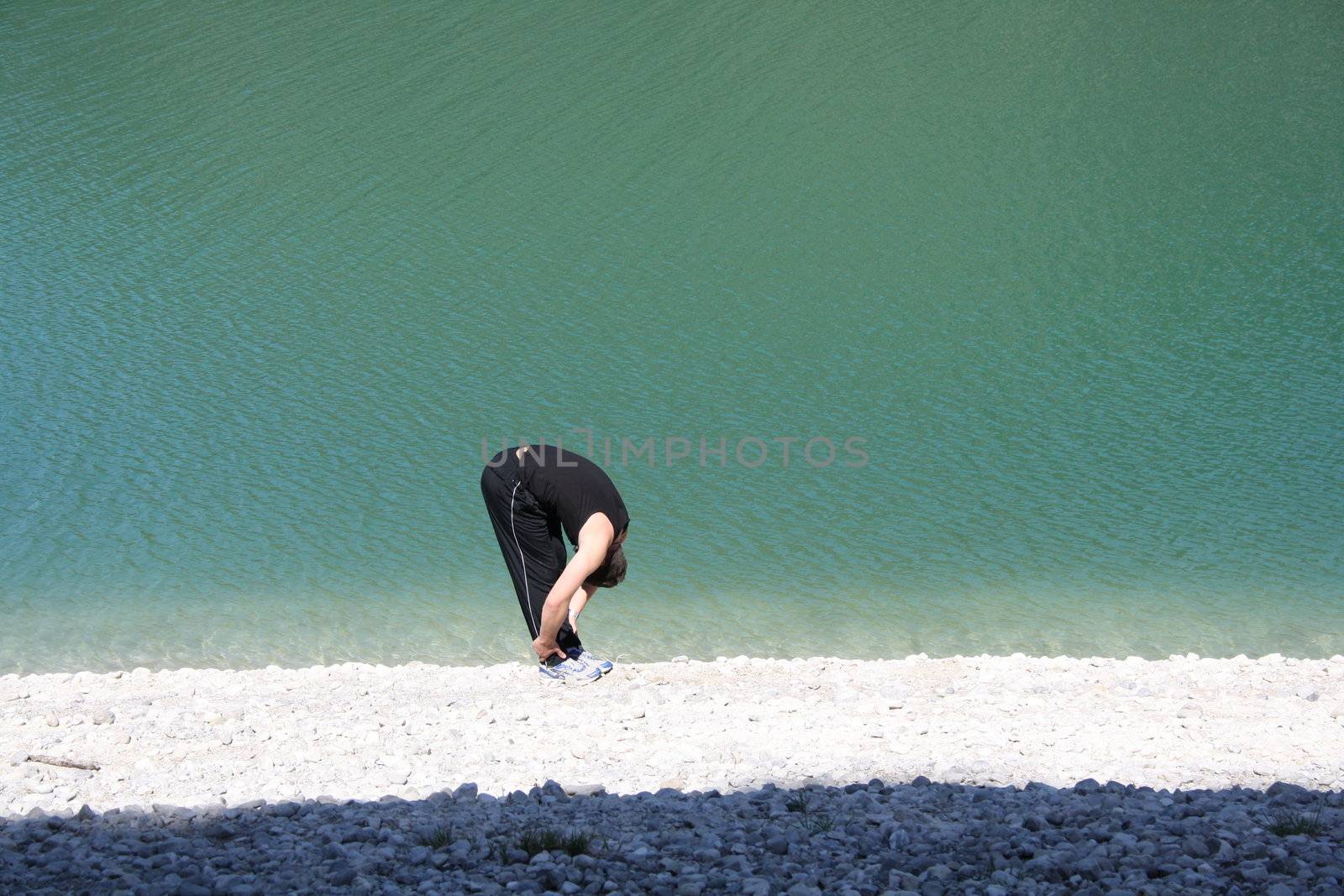 Young man stretching on beach