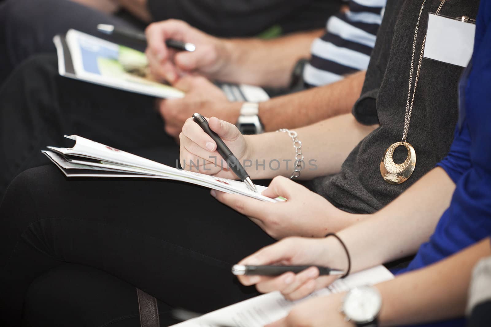 Row of people with papers adn pencils