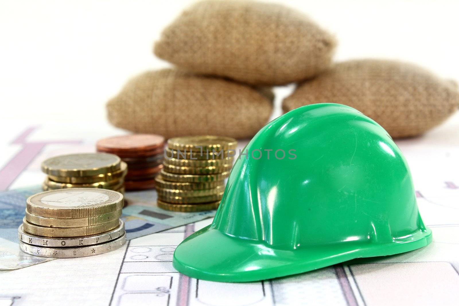 Construction helmet with euros on a housing plan