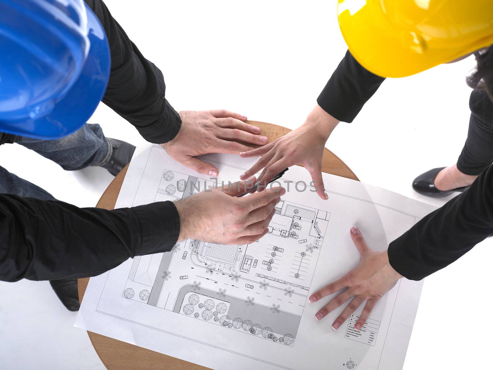 Two architects with hard hats and plan on meeting in office