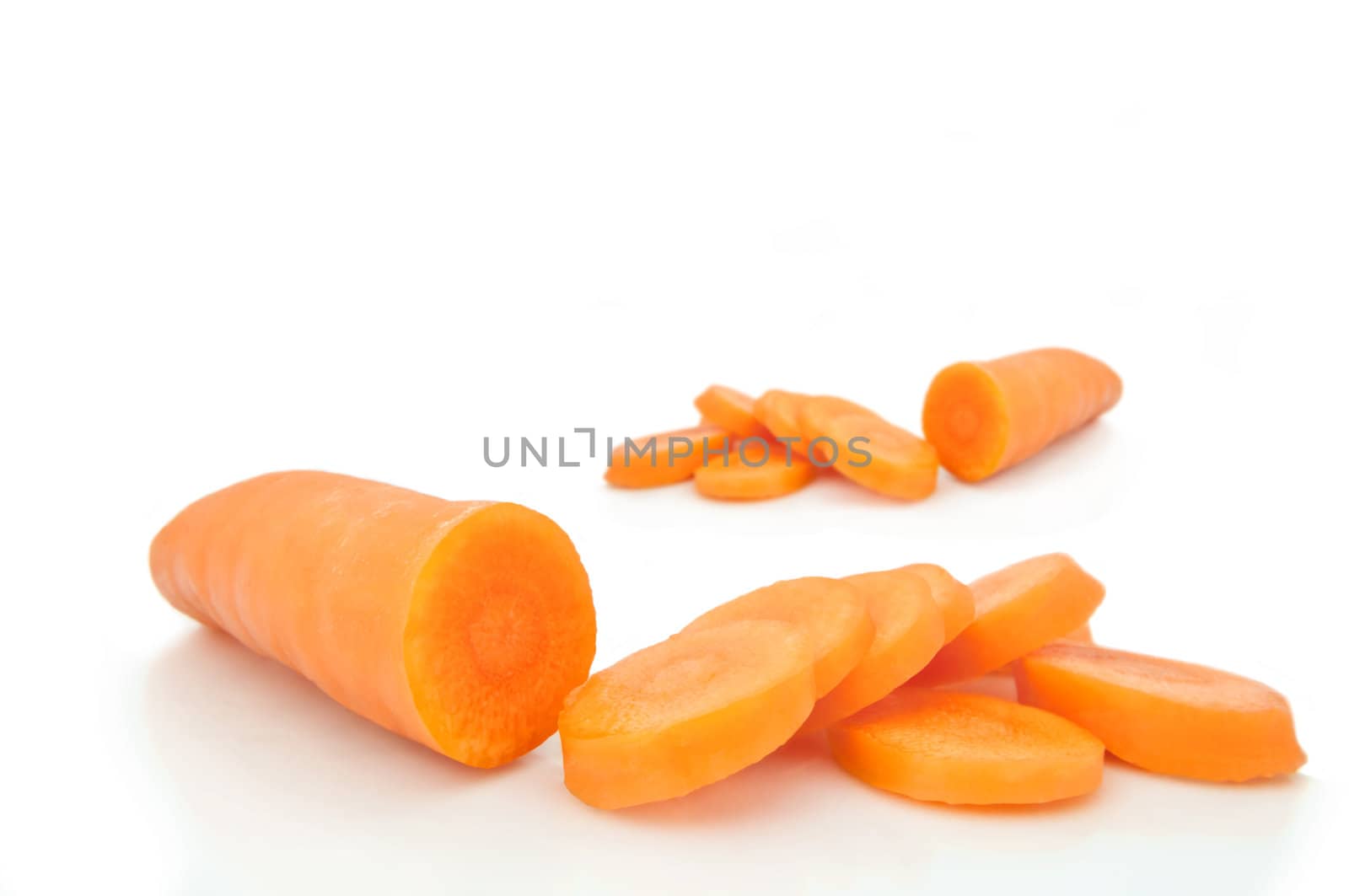 Close and low level capturing a partially sliced fresh organic carrot