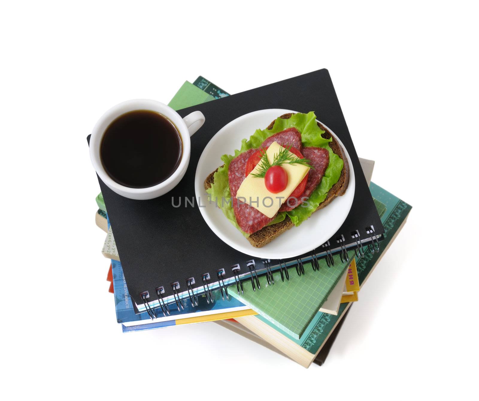 A stack of books and notebooks with a cup of coffee and a sandwich upstairs isolated