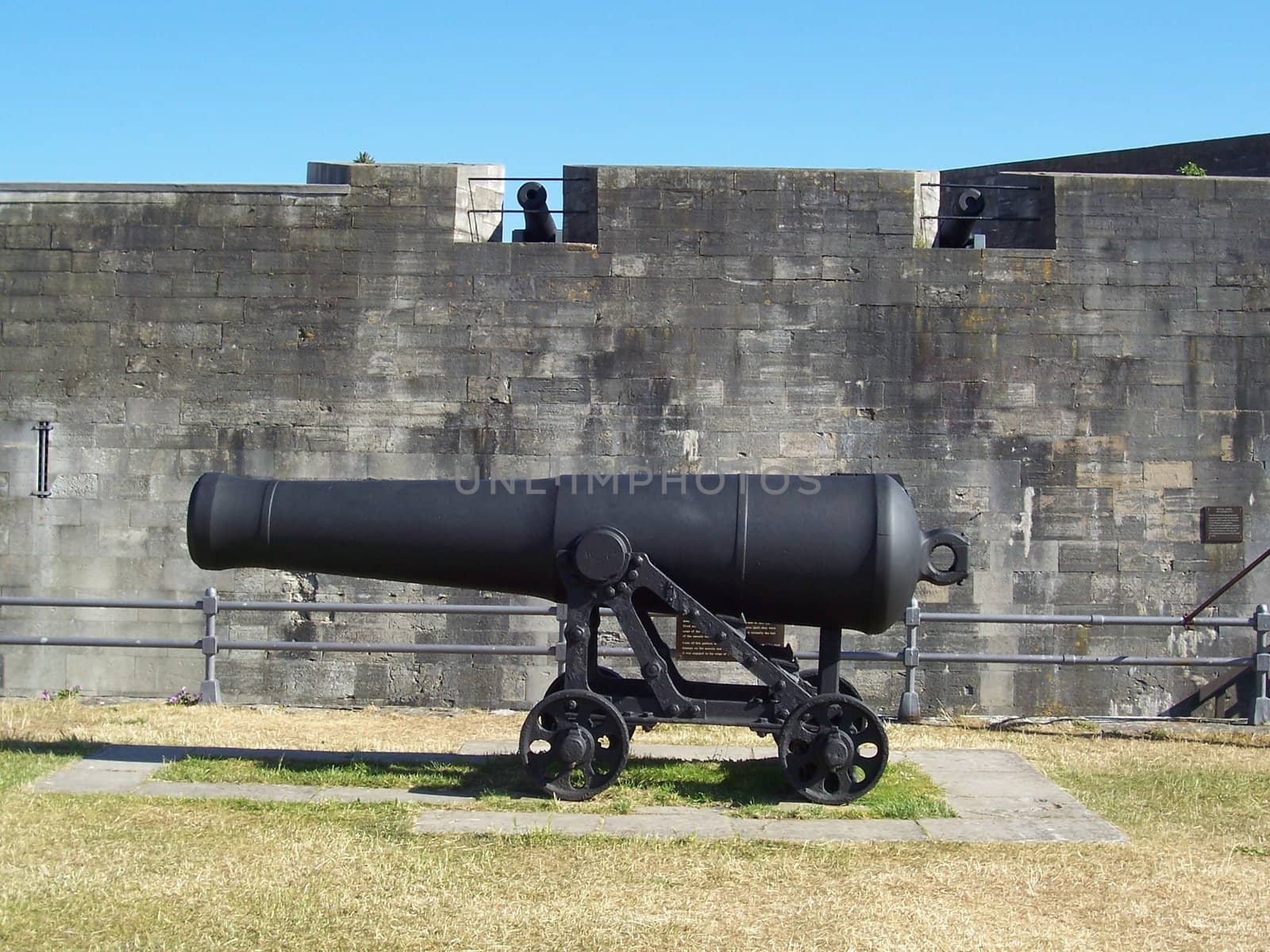 Photo of an old cannon in front of a castle wall