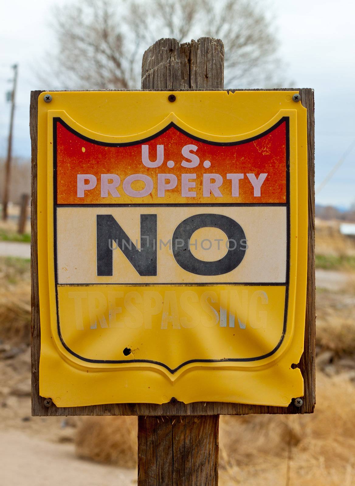A photograph of an old U.S. Property NO TRESPASSING sign.