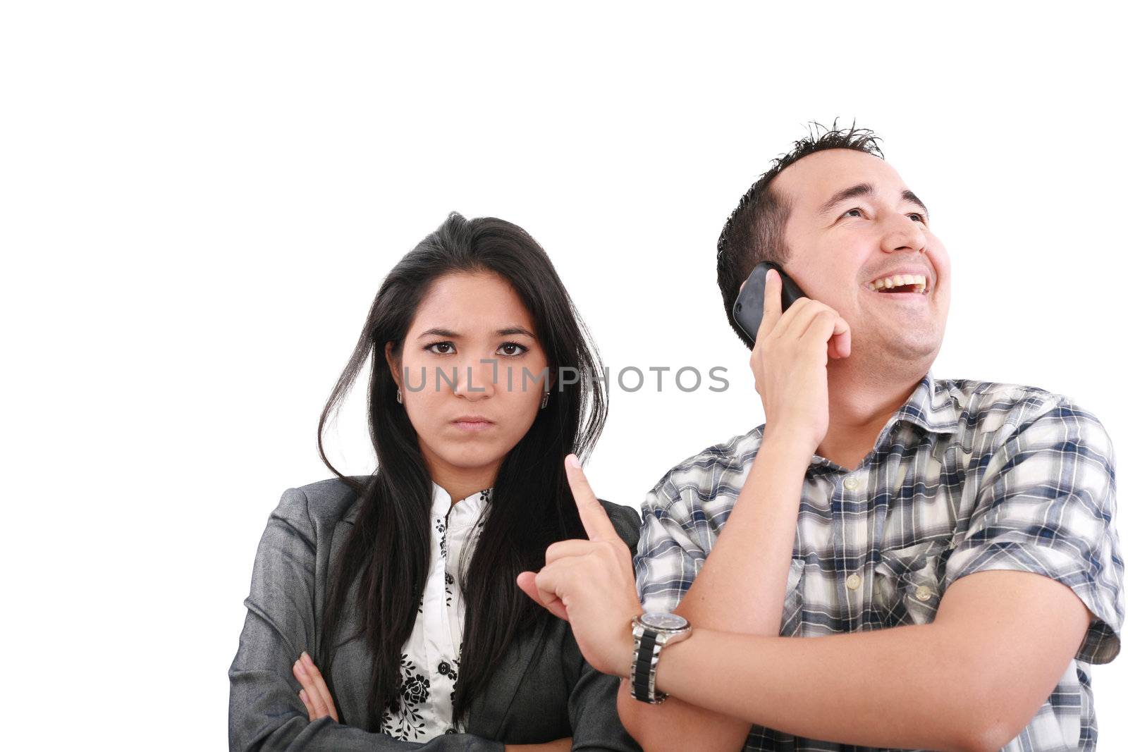 Impatient woman standing with arms crossed looking at his boyfriend listening on the mobile phone