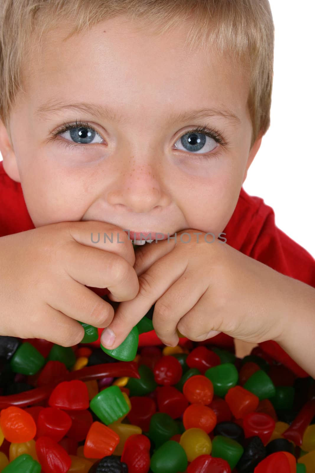 Young boy with a table full of colorful sweets 