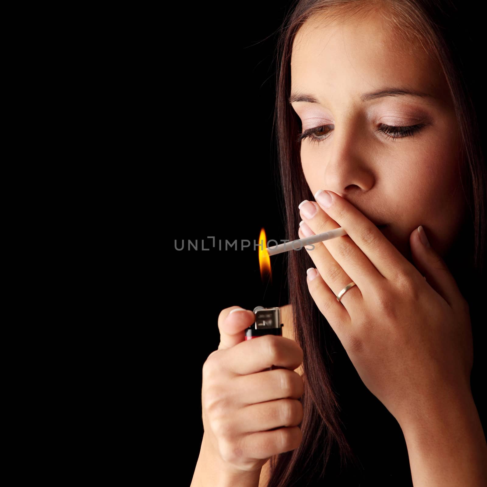 Young woman smoking over black background