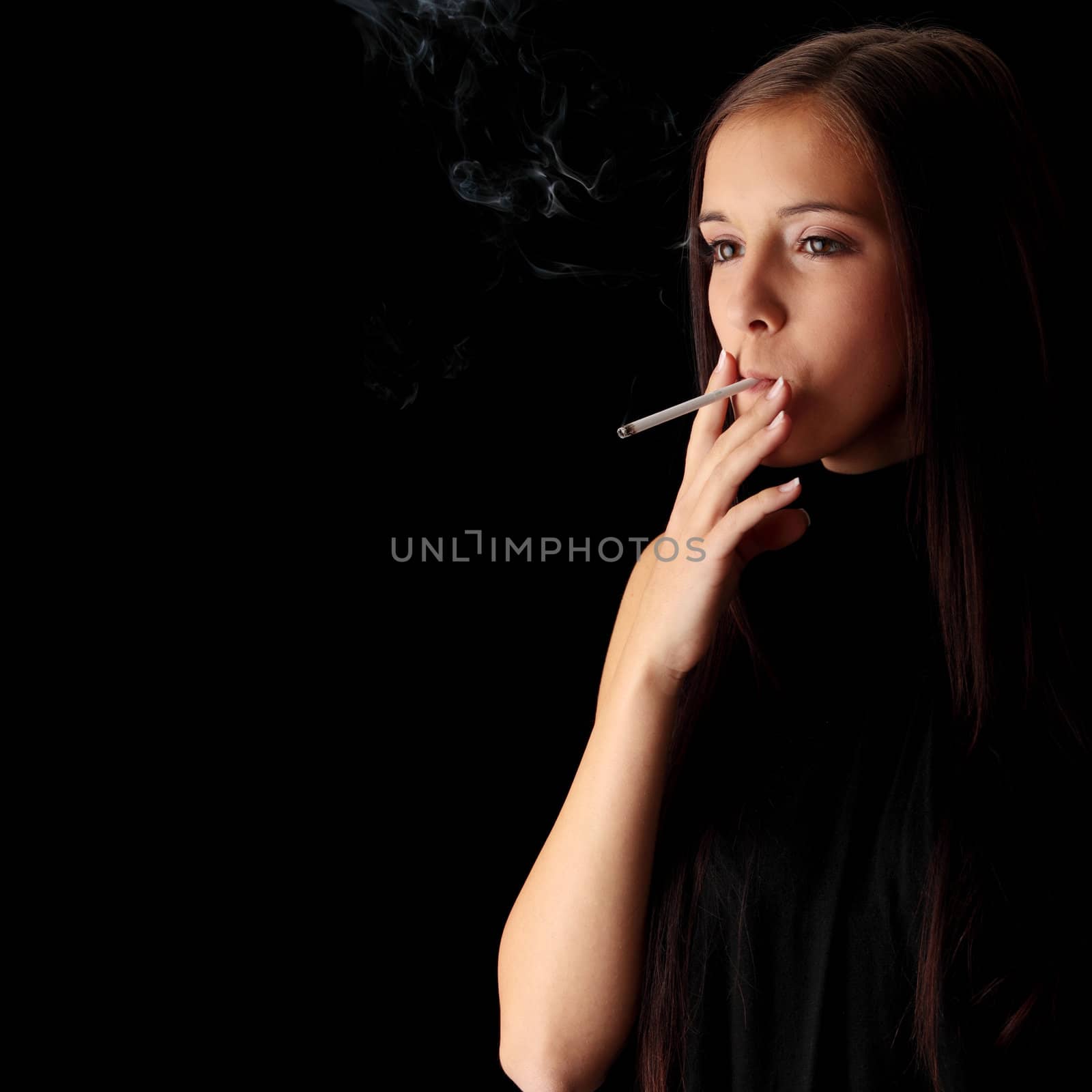 Young woman smoking over black background