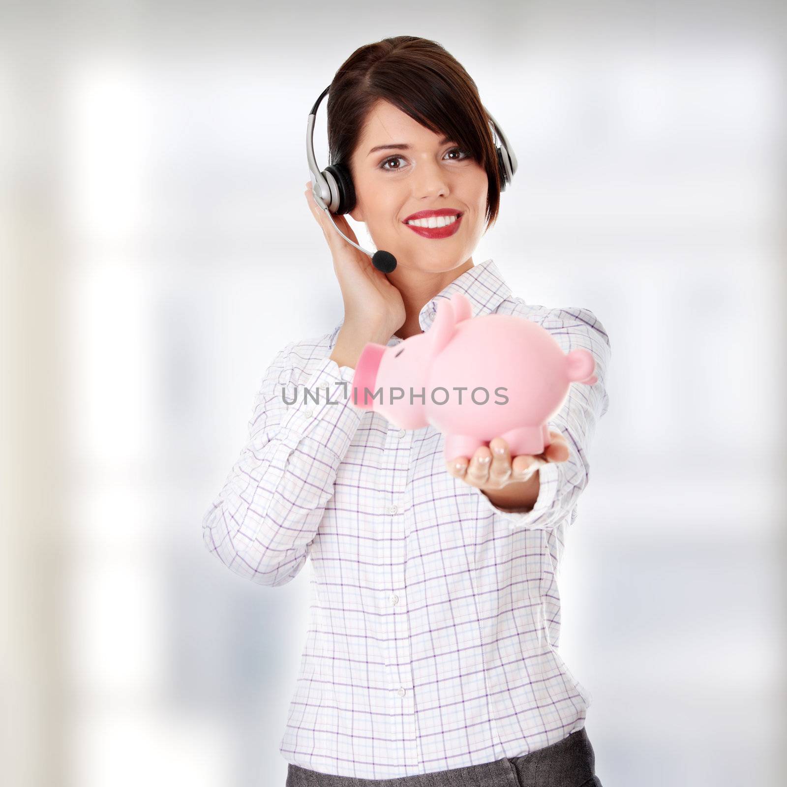 Young business woman with headset holding piggy bank